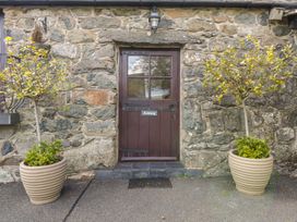 An entrance door surrounded by stone wall and planters at Cyffdy Cottage - Arenig in Bala