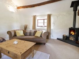 A living room with a sofa and fireplace at Cyffdy Cottage - Arenig in Bala