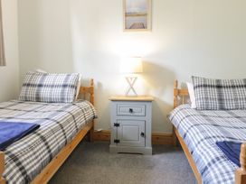 A bedroom with two beds and a nightstand at Cyffdy Cottage - Arenig