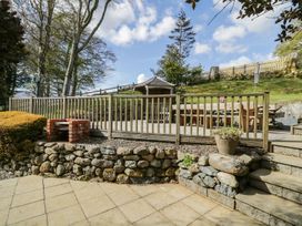 An outdoor area with a wooden deck and seating at Cyffdy Cottage - Arenig Bala