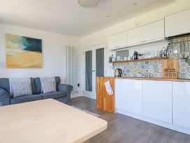 A kitchen and living area with a blue sofa and patterned tiled backsplash at Meadows Edge in Perranwell near Goonhavern