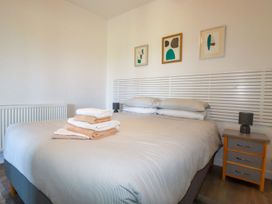 A bedroom with a bed and folded towels on it with a nightstand and lamp at Meadows Edge in Perranwell near Goonhavern