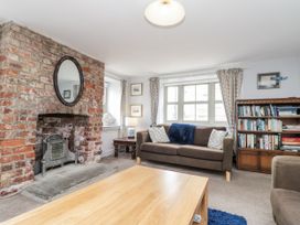 A living room with a fireplace and bookshelf at Shelstone in Whitby