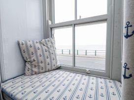 A sitting area with a window and cushions at Shelstone in Whitby