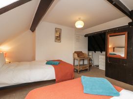 A bedroom with two beds and a mirror at Shelstone in Whitby