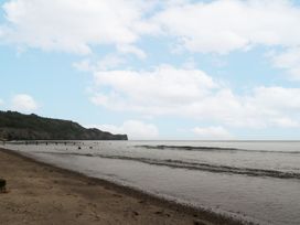 A beach scene with water and a pier at Shelstone in Whitby