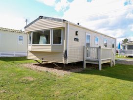 A beige mobile home with a small porch on a grassy plot at 4 Foxburrow Hang in Fritton near Belton Norfolk