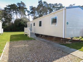 A mobile home with steps leading to the entrance on a grassy plot with trees in the background at 4 Foxburrow Hang in Fritton near Belton Norfolk