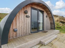 A wooden pod with curved roof and glass double doors on a wooden deck at Creags in Cullipool Isle Of Luing