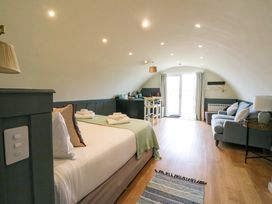 A bedroom with a bed towels a sofa table and chairs and glass doors at Creags in Cullipool Isle Of Luing