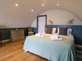 A bedroom with a double bed folded towels wooden chest of drawers and a chair at Creags Cullipool Isle Of Luing