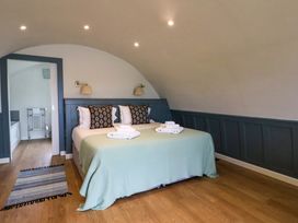 A bedroom with a double bed and folded towels on a green blanket at Creags in Cullipool Isle Of Luing