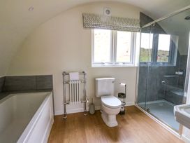 A bathroom with a bathtub radiator toilet shower and window at Creags Cullipool Isle Of Luing