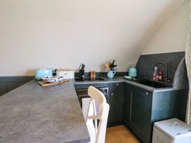 A kitchen with grey countertops a sink a kettle a toaster and kitchen utensils at Creags Cullipool Isle Of Luing