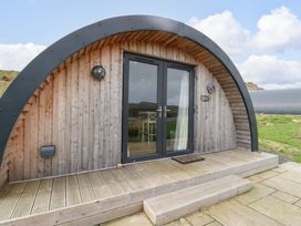 A wooden curved pod with glass double doors and a small wooden porch at Erraid in South Cuan near Cullipool Isle Of Luing