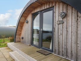 A wooden cabin with glass double doors and a small porch at Erraid South Cuan near Cullipool Isle Of Luing