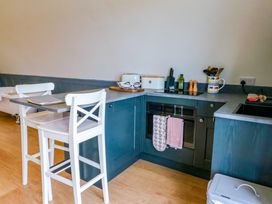 A kitchen with white chairs and a countertop with kitchen utensils at Erraid in South Cuan near Cullipool Isle Of Luing