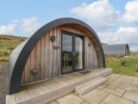 A small wooden cabin with curved roof and glass double doors on wooden deck at Insh Cullipool Isle Of Luing