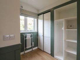 A room with a window radiator closet with white louvered doors and open shelves at Sula Cullipool Isle Of Luing