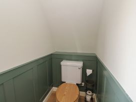 A small bathroom with a toilet and green paneled walls at Sula Cullipool Isle Of Luing