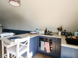 A kitchen with blue cabinets white chairs and cooking utensils at Scarba in Cullipool Isle Of Luing