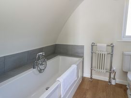 A bathroom with a bathtub a towel on the bathtub radiator with a small towel and a toilet at Torsa Cullipool Isle Of Luing