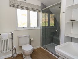 A bathroom with a toilet sink glass shower cubicle towel radiator and a window at Torsa Cullipool Isle Of Luing