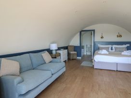 A bedroom with a bed sofa bedside table lamp and chair at Torsa Cullipool Isle Of Luing