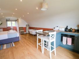 A private room with a bed bathtub kitchen counter and two chairs at Fladda in Cullipool Isle Of Luing