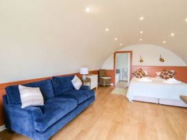 A bedroom with a blue sofa two beds and a small dresser at Losal in Cullipool Isle Of Luing