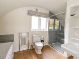 A bathroom with a bathtub radiator toilet glass shower and sink at Losal Cullipool Isle Of Luing