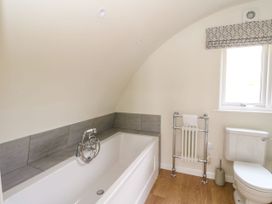 A bathroom with a bathtub a toilet a heated towel rail and a window at Losal in Cullipool Isle Of Luing