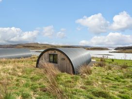 An arched cabin on grassland near water with hills and clouds at Losal in Cullipool Isle Of Luing