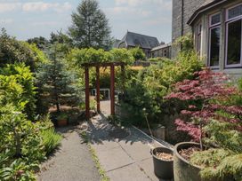 A garden with a pathway and archway at Lilac Cottage in Grange-Over-Sands