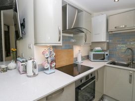 A kitchen with a sink and appliances at Lilac Cottage in Grange-Over-Sands