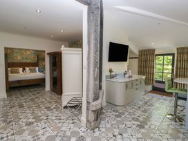 A bedroom with a bed and wardrobe at Lilac Cottage Grange-Over-Sands
