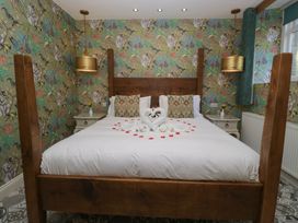 A bedroom with a bed and decorative items at Lilac Cottage in Grange-Over-Sands