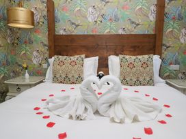 A bedroom with a bed and towel swans at Lilac Cottage in Grange-Over-Sands