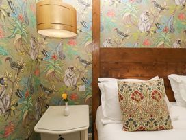 A bedroom with a bed and decorative nightstand at Lilac Cottage in Grange-Over-Sands