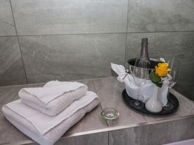 A bathroom with towels and champagne on a tray at Lilac Cottage in Grange-Over-Sands