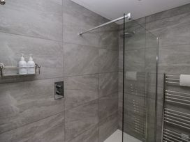 A shower area with a glass panel at Lilac Cottage in Grange-Over-Sands