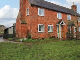 A house with a brick exterior and greenery at 1 Dingle Cottage in Worcester