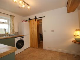 A kitchen with a fridge and washing machine at 1 Dingle Cottage in Worcester
