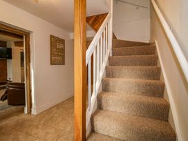 A staircase with carpet and a sign on the wall at 1 Dingle Cottage in Worcester