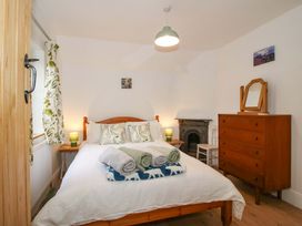 A bedroom with a double bed and furniture at 1 Dingle Cottage in Worcester
