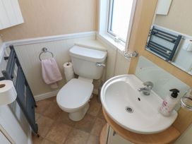 A bathroom with a toilet sink towel radiator and window at Plot 6 near Armathwaite