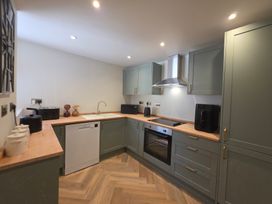 A kitchen with appliances and cabinetry at Fox House in Llandudno