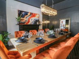 A dining room with a large table set for a meal at Fox House in Llandudno