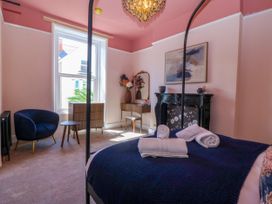A bedroom with a bed and chair at Fox House in Llandudno