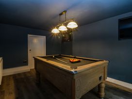 A game room with a pool table and dart board at Fox House in Llandudno